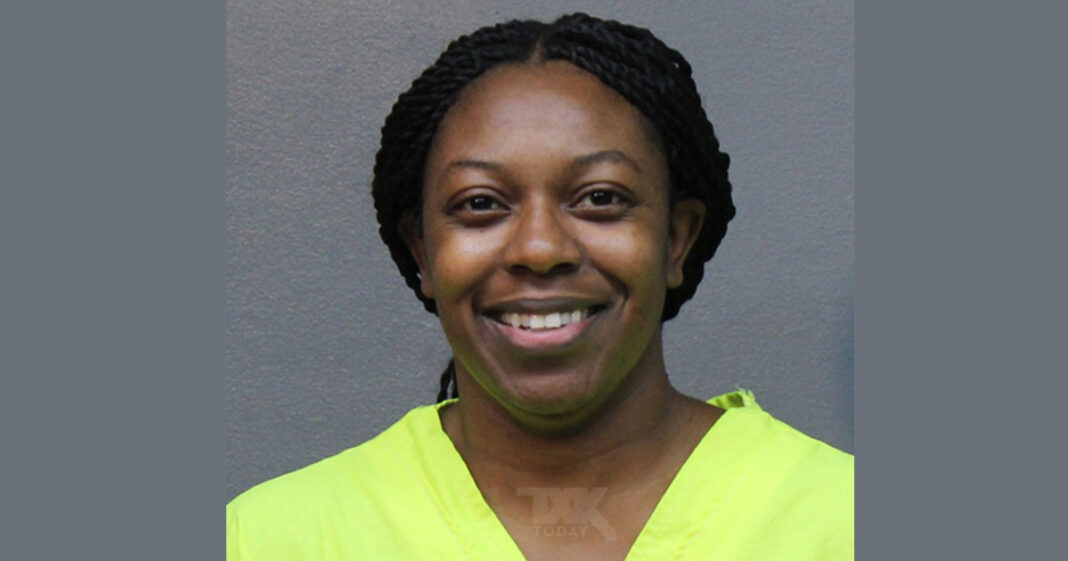 A mugshot of Benton with braided hair smiles at the camera, wearing a bright yellow top, standing in front of a plain gray background.