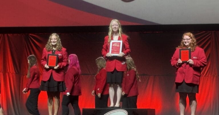 Anna Fryar stands atop the FCCLA awards podium after winning first place nationally in Early Childhood Education.