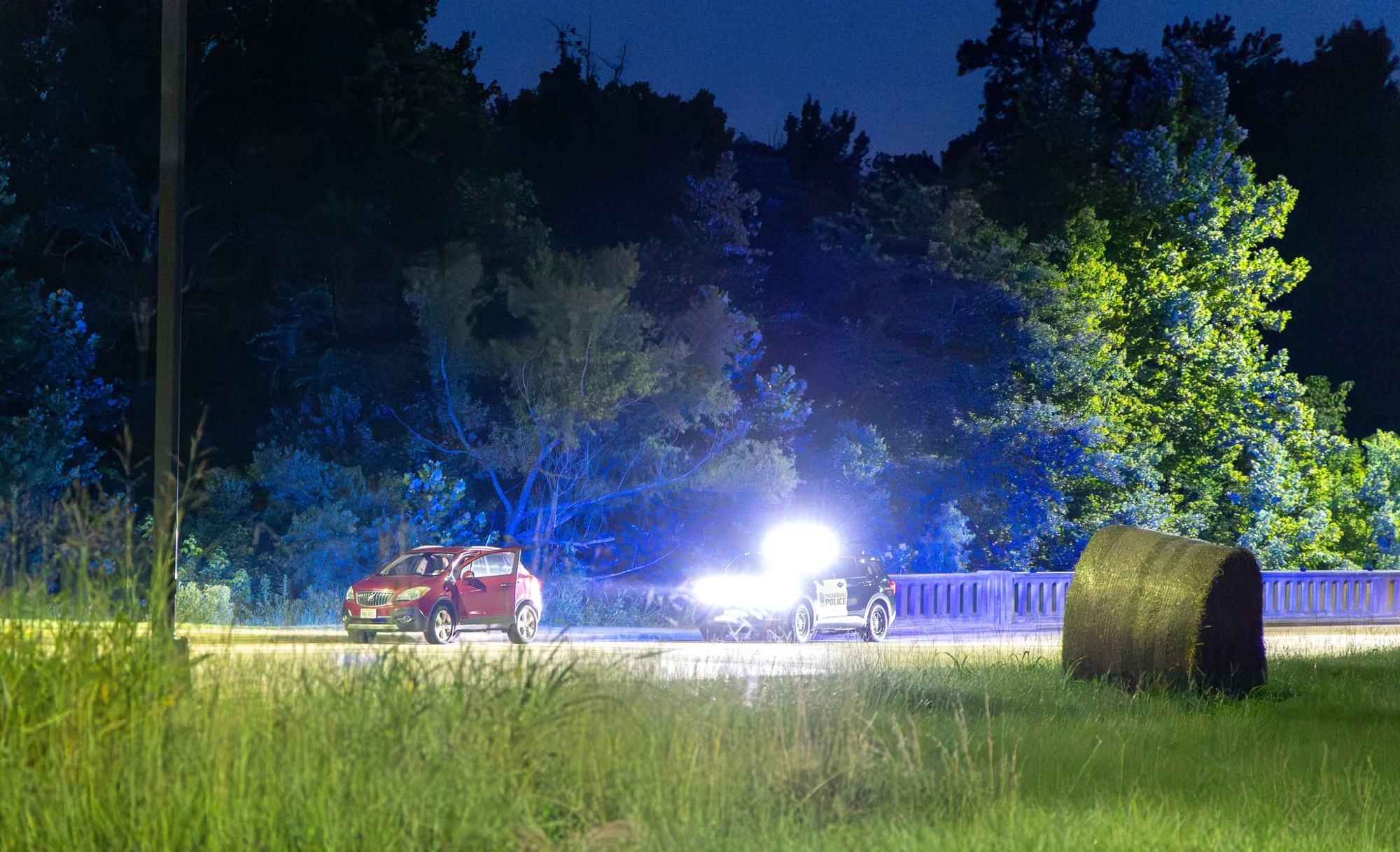 Texarkana Texas police unit stopped behind a red SUV at night near Bringle Lake Park