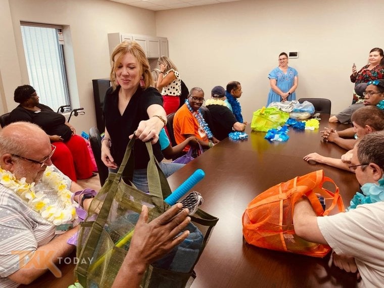 A resident of Haven Home receives a beach bag during a send-off before the group trip to Galveston, Texas