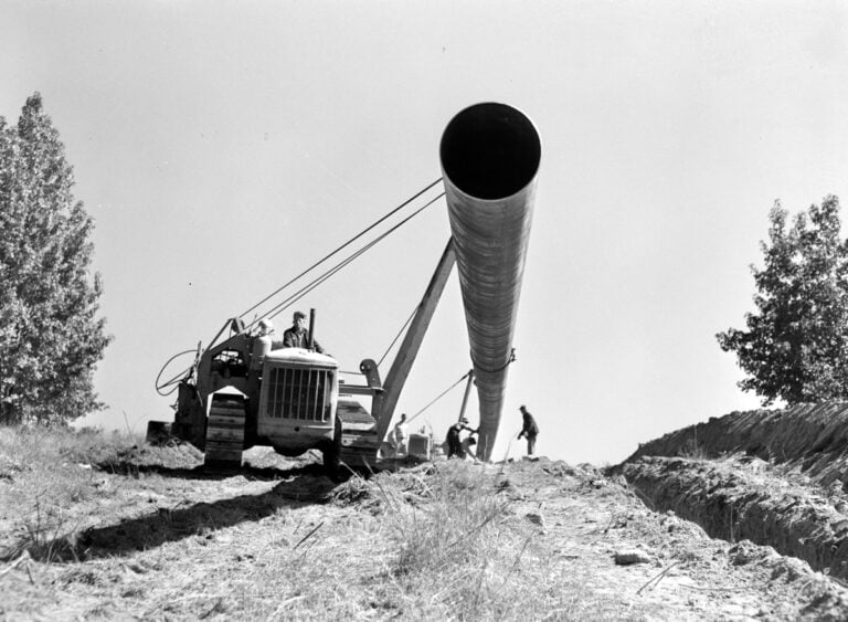 Crews hoist a 200-foot welded section of pipe in East Texas before lowering it into the ditch. Photo: John Vachon, Office of War Information, Library of Congress. 200-foot welded section of Big Inch pipe hoisted by tractors, 1942