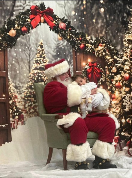 Santa with a sleeping child at Festival of Trees Breakfast with Santa