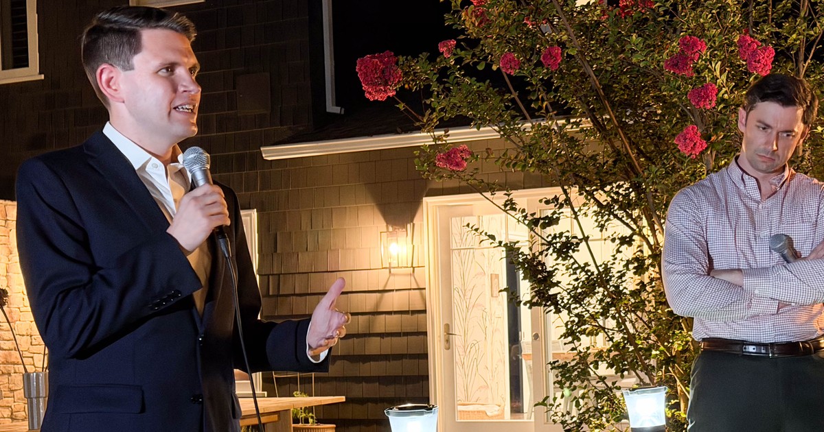 James Talarico in a navy blazer speaking into a handheld microphone at an outdoor evening campaign event, with Jon Ossoff standing behind him with arms crossed
