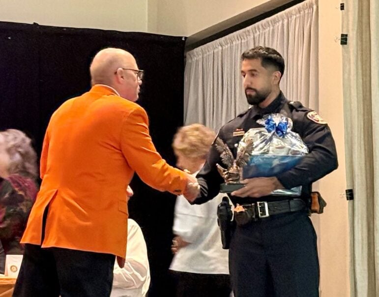 Texarkana, Texas, Mayor Bob Bruggeman shakes hands with police Officer Jacob Miramontes at the Rotary banquet.