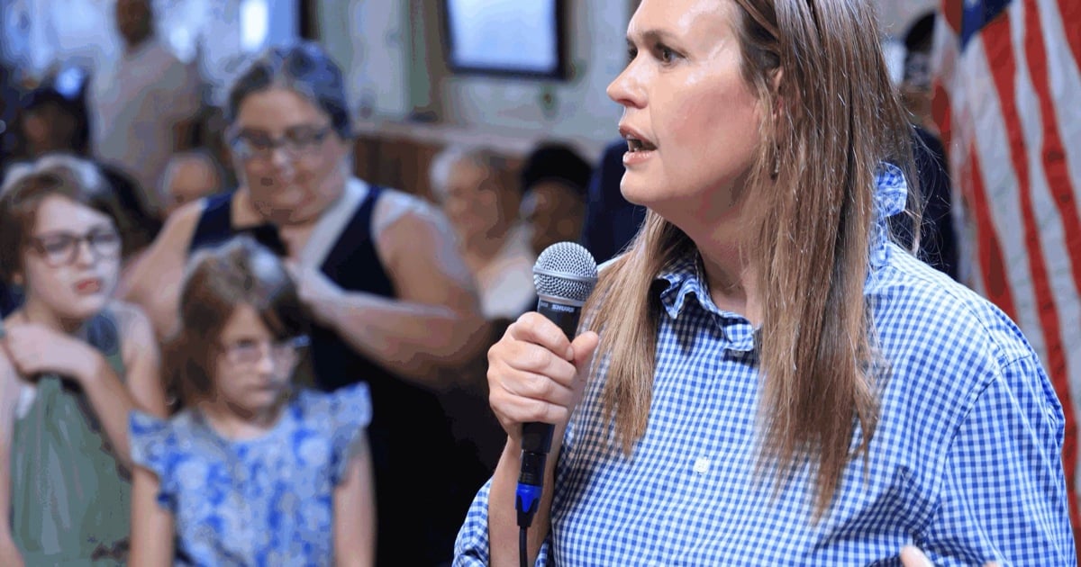 Arkansas Gov. Sarah Huckabee Sanders speaks into a microphone to a crowd at Zapata's restaurant in Texarkana