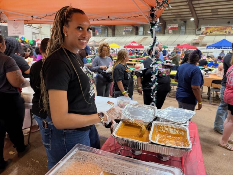 Smiling Chili's server dishing up samples at a red-draped table