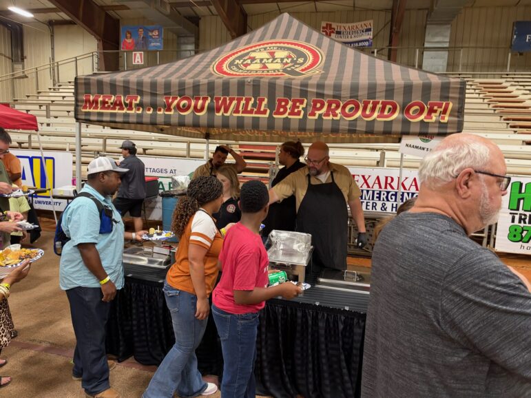 Line of guests at Naaman's BBQ tent under a striped canopy