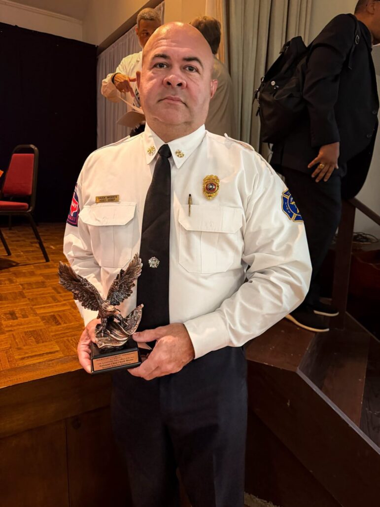 Texarkana, Texas, Assistant Fire Chief Chuck Weerts holds a bronze eagle trophy at the Rotary banquet.