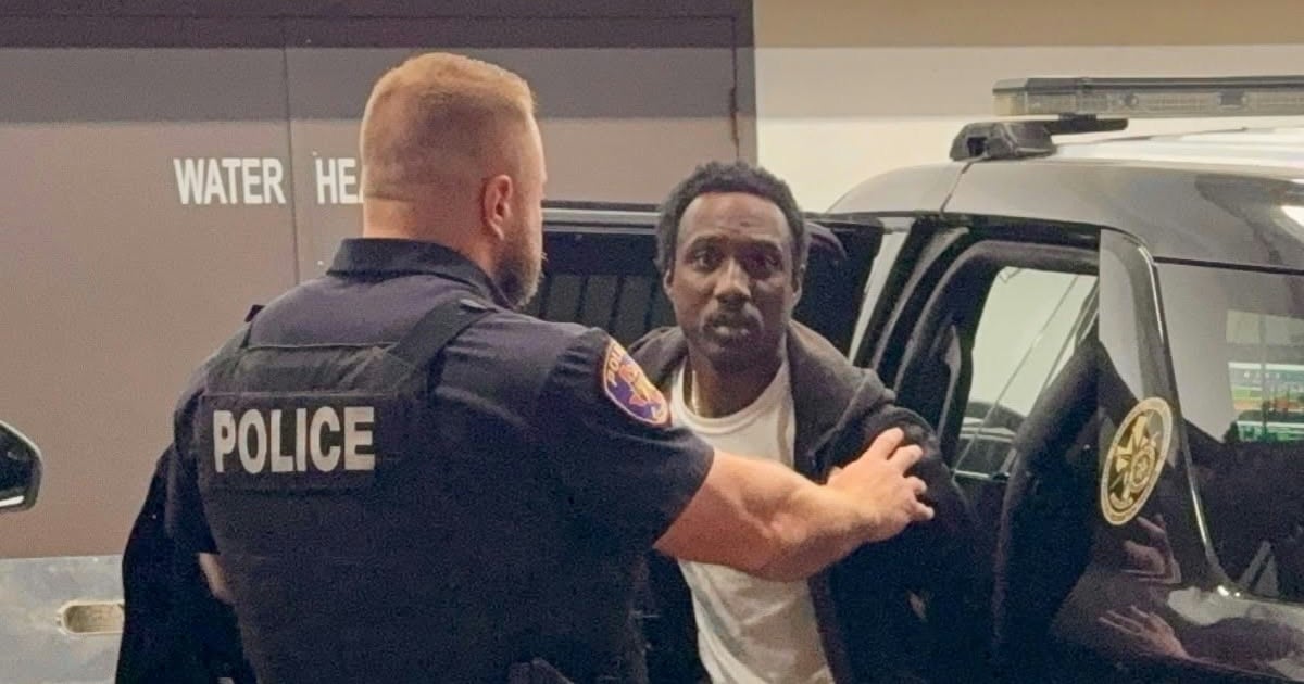 A Texarkana, Texas, police officer escorts Willie Fobbs from a patrol vehicle